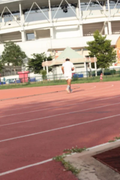 Homem desfocado correndo pista para no estádio . — Fotografia de Stock