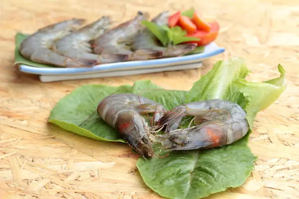 Camarones frescos y verduras verdes en el plato — Foto de Stock