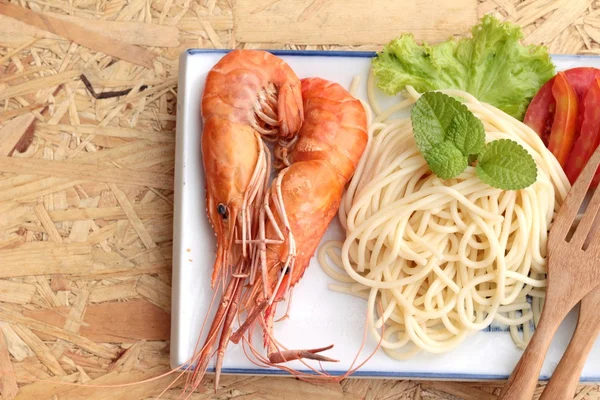 Těstoviny špagety s krevetami na desku. — Stock fotografie