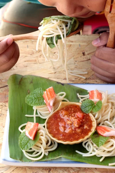 Pasta spaghetti with crab sticks and sauce.