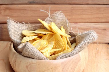 Potato chip on wood background