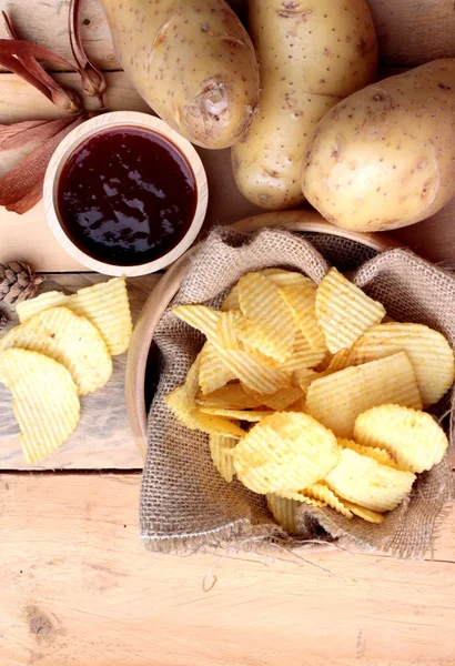 Patates cipsi ve ahşap zemin üzerine taze patates — Stok fotoğraf