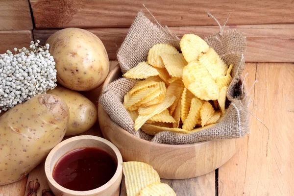 Batata frita e batatas frescas sobre fundo de madeira — Fotografia de Stock