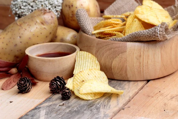 Batata frita e batatas frescas sobre fundo de madeira — Fotografia de Stock