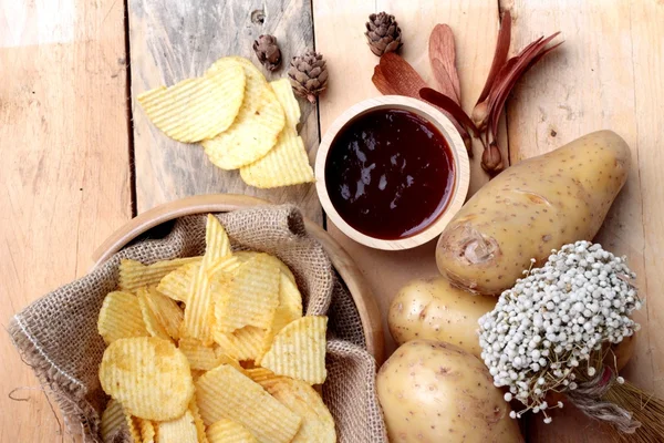 Patates cipsi ve ahşap zemin üzerine taze patates — Stok fotoğraf