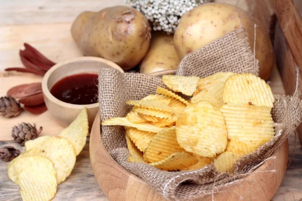 Batata frita e batatas frescas sobre fundo de madeira — Fotografia de Stock