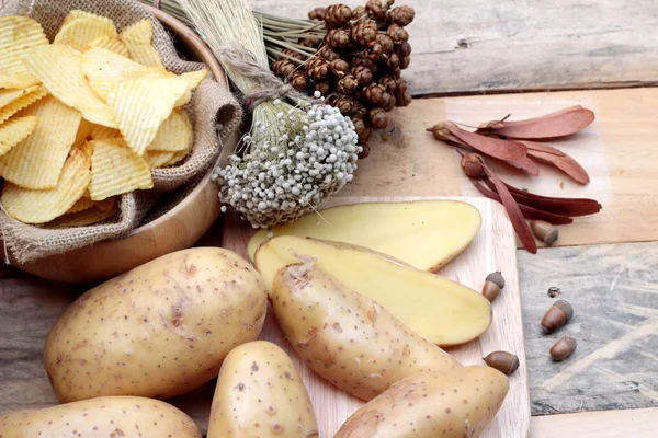 Batata frita e batatas frescas sobre fundo de madeira — Fotografia de Stock