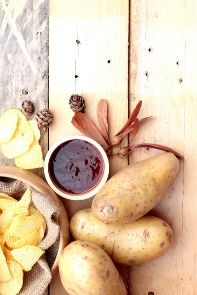 Patates cipsi ve ahşap zemin üzerine taze patates — Stok fotoğraf