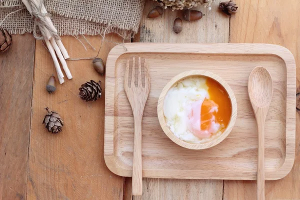 Huevos y huevos cocidos sobre fondo de madera — Foto de Stock