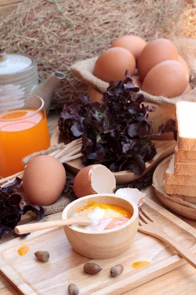 Huevos y huevos cocidos sobre fondo de madera — Foto de Stock