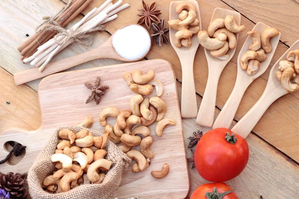 Anacardi arrosto noci con naturale su sfondo di legno — Foto Stock