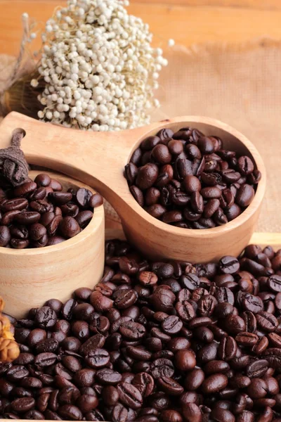 Rostade kaffebönor på säck brun bakgrund. — Stockfoto