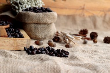 Çuval kahverengi zemin üzerine kavrulmuş kahve çekirdekleri.