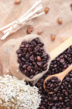 Çuval kahverengi zemin üzerine kavrulmuş kahve çekirdekleri.