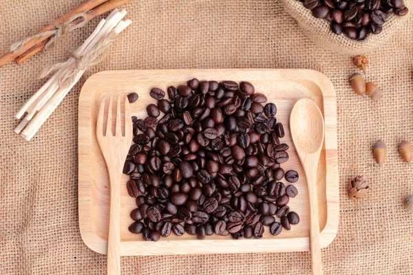 Grains de café torréfiés sur fond brun sac . — Photo