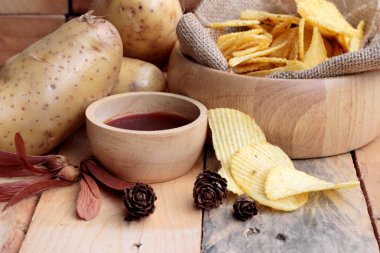 Patates cipsi ve ahşap zemin üzerine taze patates