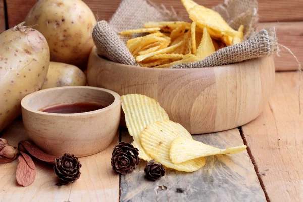Batata frita e batatas frescas sobre fundo de madeira — Fotografia de Stock