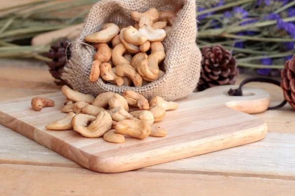 Anacardi arrosto noci con naturale su sfondo di legno — Foto Stock