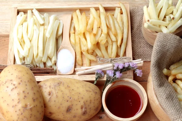 Frytki i świeże pokrojone ziemniaki z ketchupem. — Zdjęcie stockowe