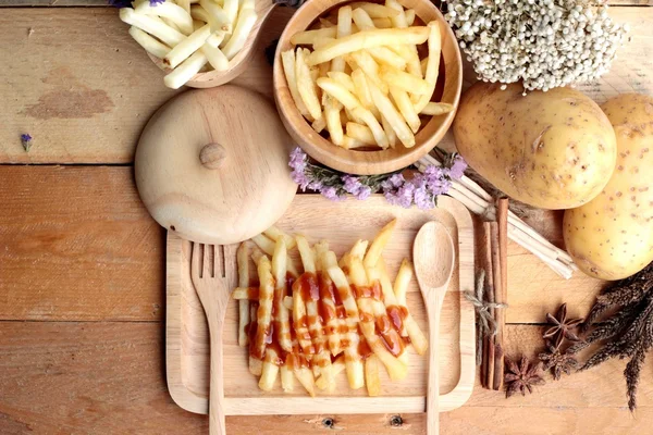 Frytki i świeże pokrojone ziemniaki z ketchupem. — Zdjęcie stockowe