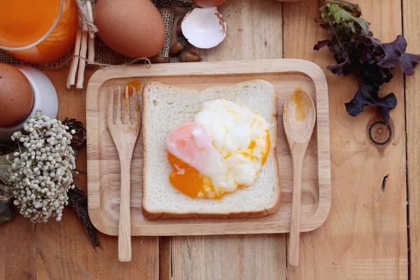 Löskokta ägg med bröd på trä bakgrund. — Stockfoto