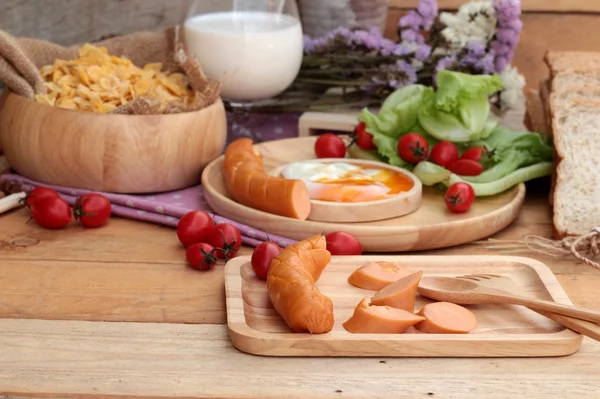 Breakfast with eggs, sausage, bread, salad vegetables and milk. — Stock Photo, Image