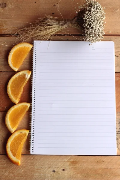 Diary book with fruit, orange slice on wooden background. — Stock Photo, Image