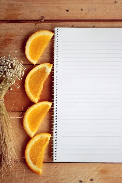 Diario con fruta, rebanada de naranja sobre fondo de madera . —  Fotos de Stock