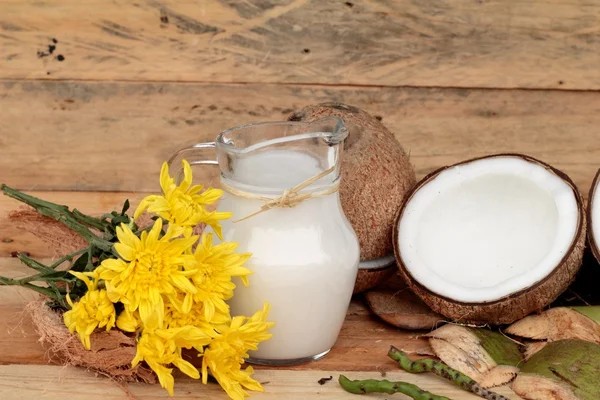 Weiße Kokosnuss und Milch auf Holz Hintergrund — Stockfoto