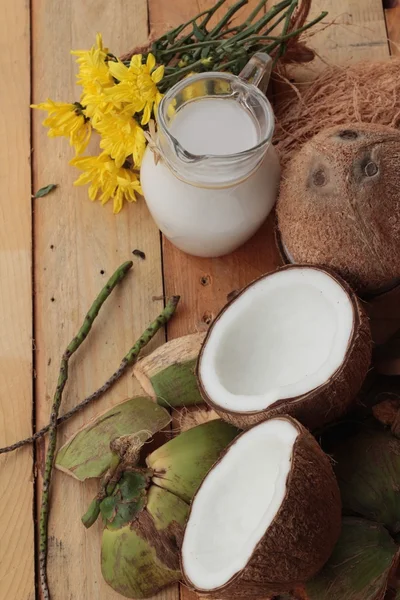 Noix de coco blanche et lait sur fond de bois — Photo