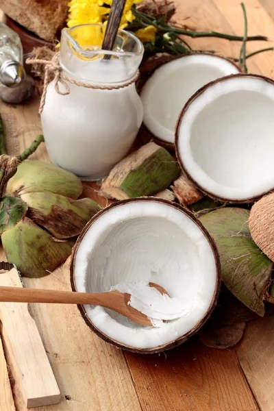 Weiße Kokosnuss und Milch auf Holz Hintergrund — Stockfoto