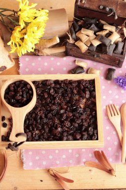 Bir ahşap tepsi üzerinde kurutulmuş kuş üzümü.