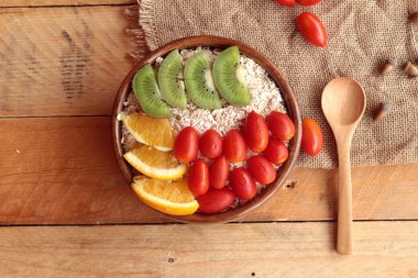 Meyve, kivi, portakal, domates, kivi suyu ile yulaf gevreği.