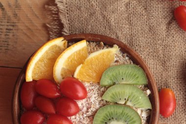 Meyve, kivi, portakal, domates, kivi suyu ile yulaf gevreği.