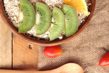 Meyve, kivi, portakal, domates, kivi suyu ile yulaf gevreği.