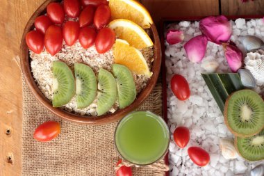 Meyve, kivi, portakal, domates, kivi suyu ile yulaf gevreği.