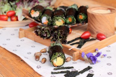 Sebze salatası ile deniz yosunu böreği sarılmış..