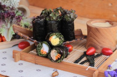 Sebze salatası ile deniz yosunu böreği sarılmış..