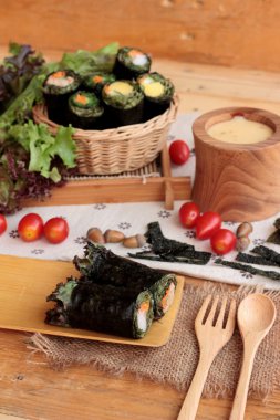 Sebze salatası ile deniz yosunu böreği sarılmış..