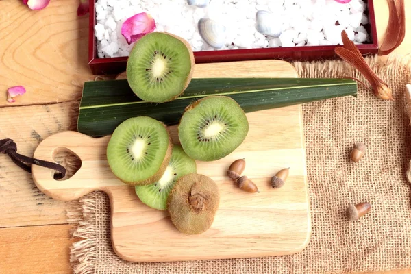 Kivi meyve sulu yeşil ahşap arka plan üzerinde.