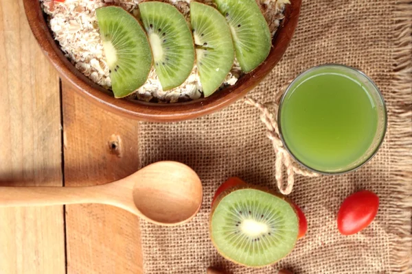 Flocos de aveia com frutas, kiwi, laranja, tomate e suco de kiwi . — Fotografia de Stock