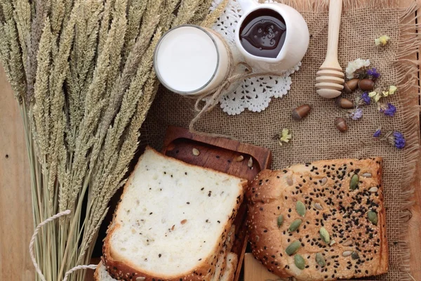 Brown bread with whole grain cereals of sliced and milk. — Stock Photo, Image