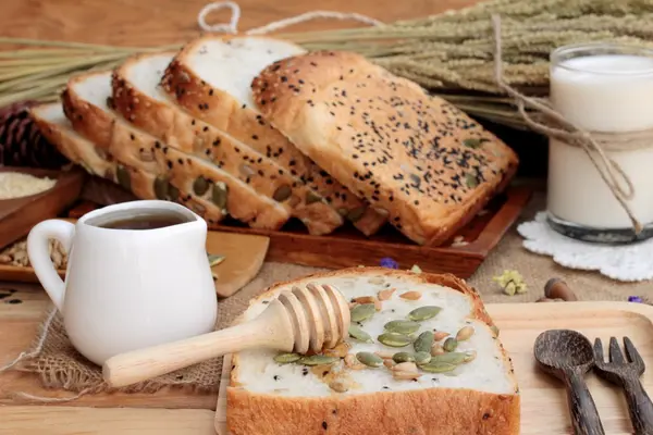 Pão integral com cereais integrais, cortados em fatias e leite . — Fotografia de Stock