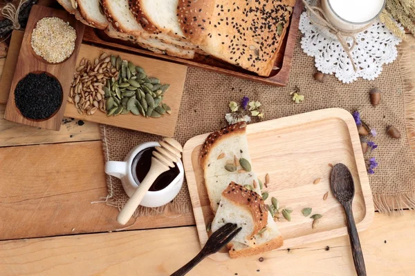 Pão integral com cereais integrais, cortados em fatias e leite . — Fotografia de Stock