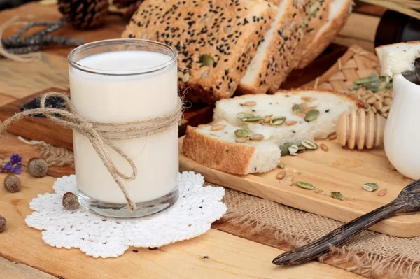 Tmavý chléb s celozrnné obiloviny na plátky a mléko. — Stock fotografie