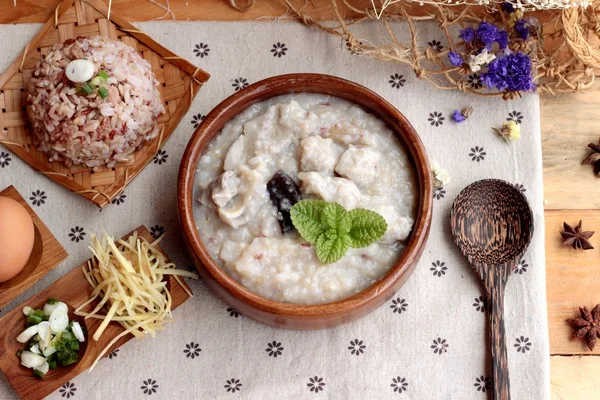 Il porridge di riso marrone mette la carne di maiale e il riso marrone con uovo alla coque morbido — Foto Stock