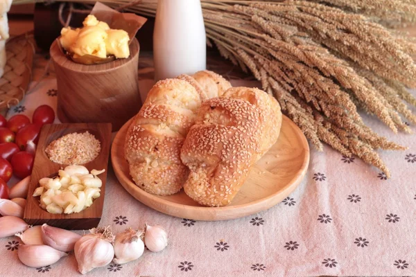 Sarımsaklı ekmek ot ahşap arka plan üzerinde lezzetli.