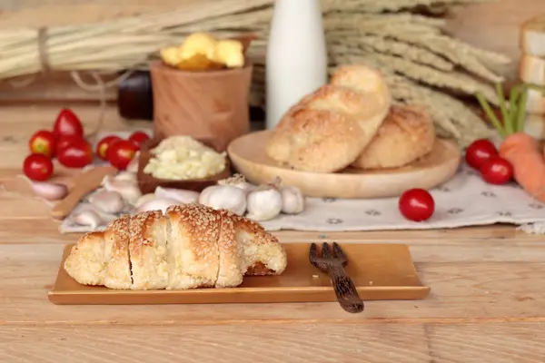 Sarımsaklı ekmek ot ahşap arka plan üzerinde lezzetli.