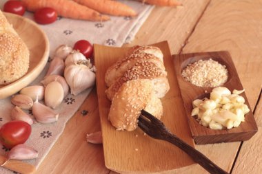 Sarımsaklı ekmek ot ahşap arka plan üzerinde lezzetli.