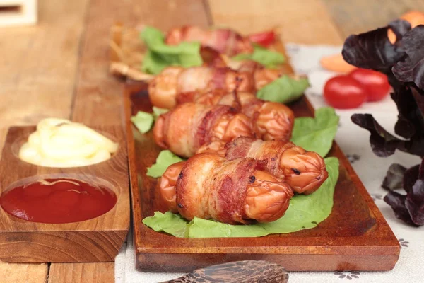 Salsichas grelhadas embrulhadas em gordura de bacon deliciosa . — Fotografia de Stock